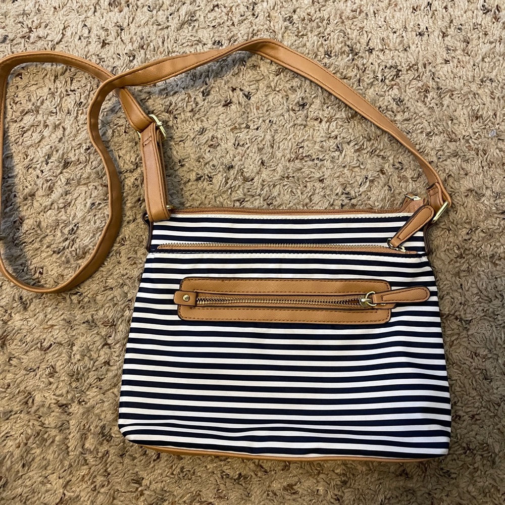 Navy blue and white striped crossbody bag. Tan interior.